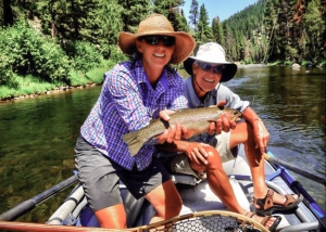 fishing guide on bitterroot river montana holding trout with happy fisherman